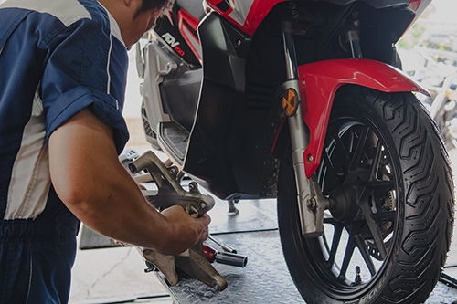 スタッフがバイクの修理をしている